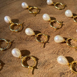 Rebecca Yellow Gold small pearl hoops on a wooden background
