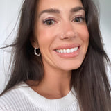 Smiling model with small pearl hoops