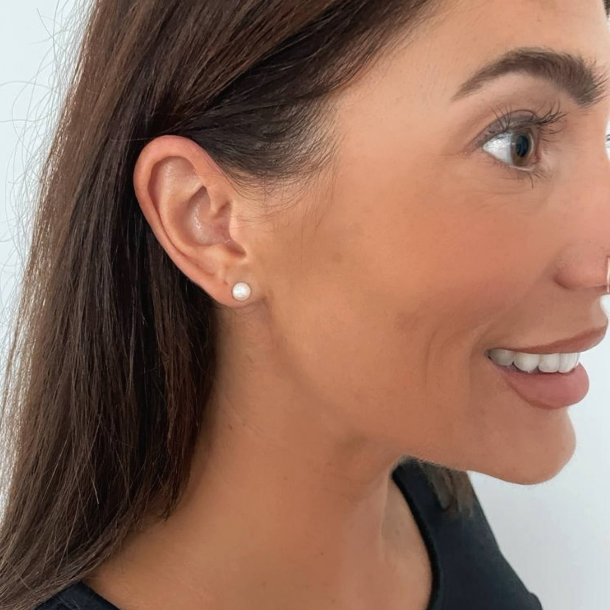 Small white pearl studs on model